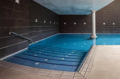 a swimming pool with blue water in a building at RVHotels Broquetas Spa Termal in Caldes de Montbui