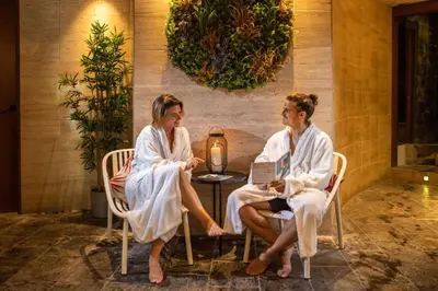 two women sitting at a table in towels at RVHotels Spa Vila de Caldes - Adults only in Caldes de Montbui