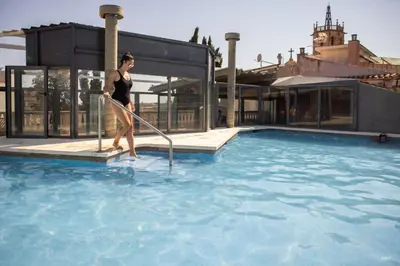 a woman is standing in a swimming pool at RVHotels Spa Vila de Caldes - Adults only in Caldes de Montbui