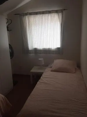 a small bedroom with a bed and a window at Old Navy House in Badalona