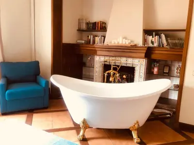 a white bath tub in a room with a fireplace at Casa les Pomeretes in El Figaró