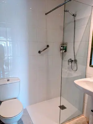 a bathroom with a shower with a toilet and a sink at Apartamentos Mitus in Canet de Mar