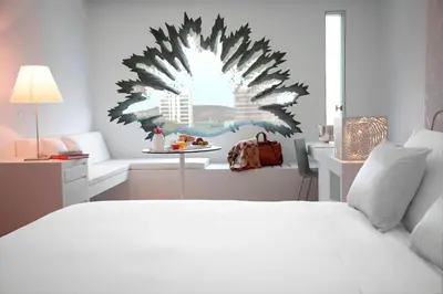 a bedroom with a large white bed and a table at Renaissance Barcelona Fira Hotel in Hospitalet de Llobregat