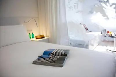 a hotel room with a white bed with a box on it at Renaissance Barcelona Fira Hotel in Hospitalet de Llobregat