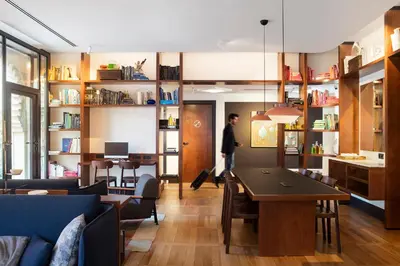 a man standing in a living room with a table at Praktik Èssens in Barcelona