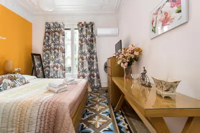 a bedroom with a bed and a desk with flowers on it at Luxury & Elegant Apartment in the centre in Barcelona