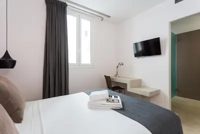 a hotel room with a bed and a television at Quartprimera Apartments in Barcelona
