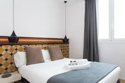 a bedroom with a large white bed and a window at Quartprimera Apartments in Barcelona