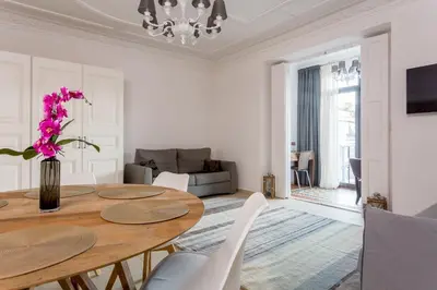a white living room with a wooden table and chairs at Quartprimera Apartments in Barcelona