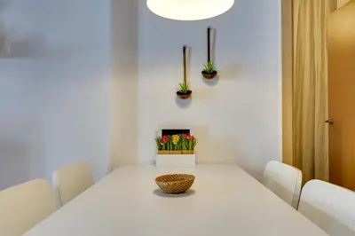 a white table with a vase of flowers on it at Charming & Convenient Apartment Near Plaza Espanya in Barcelona