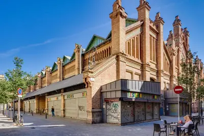 a large brick building with a clock tower on a street at Charming & Convenient Apartment Near Plaza Espanya in Barcelona