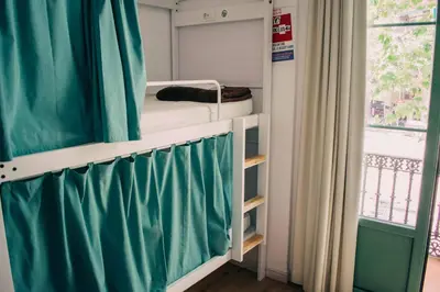 a bunk bed in a room with a window at Black Swan Hostel Barcelona in Barcelona