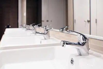 a row of sinks in a bathroom with mirrors at Black Swan Hostel Barcelona in Barcelona