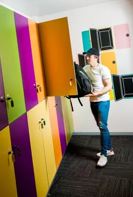a man standing in a room with a colorful door at Twentytu Hostel Barcelona in Barcelona