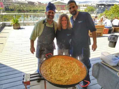 a woman and two men standing next to a large pizza at Twentytu Hostel Barcelona in Barcelona