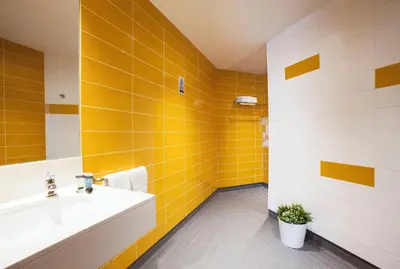 a bathroom with yellow tiles and a sink at Twentytu Hostel Barcelona in Barcelona
