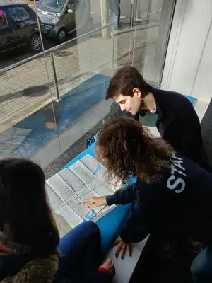 a man and a woman looking at a map at Twentytu Hostel Barcelona in Barcelona