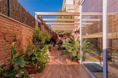 an external view of a brick building with plants at Bonito duplex con piscina en Barcelona&playa in Tiana