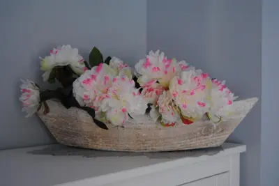 a basket of pink and white flowers on a mantle at Bonito duplex con piscina en Barcelona&playa in Tiana