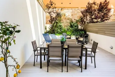 a table and chairs on a patio with plants at Cosmo Apartments Passeig de Gràcia in Barcelona