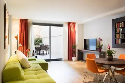 a living room with a green couch and a table at Cosmo Apartments Passeig de Gràcia in Barcelona