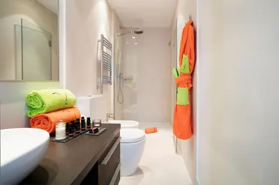 a bathroom with a white toilet and a sink at Cosmo Apartments Passeig de Gràcia in Barcelona