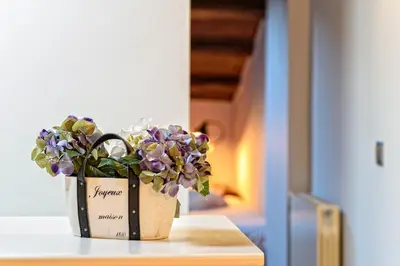 a vase with purple flowers sitting on a table at Apartamento con encanto en Badalona in Badalona