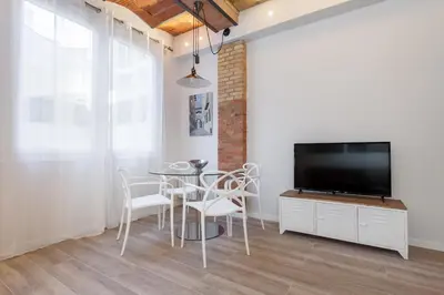 a dining room with a tv and a table and chairs at Art House Cathedral Sagrada Familia in Barcelona