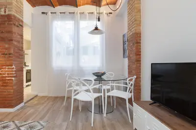 a dining room with a table and chairs and a tv at Art House Cathedral Sagrada Familia in Barcelona