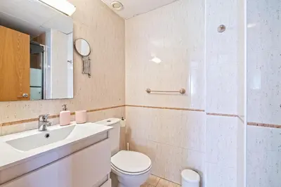 a bathroom with a sink and a toilet and a mirror at Apartamento lujo& piscina junto Barcelona Centro in Ripollet