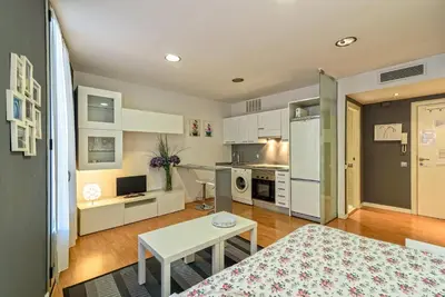 a living room with a table and a kitchen at Loft en Badalona Centro in Badalona