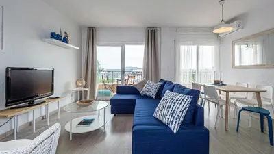 a living room with a blue couch and a tv at Bed&Bcn Glories in Barcelona