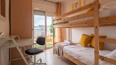 a bedroom with a bunk bed and a desk and a chair at Bed&Bcn Glories in Barcelona