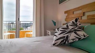a bedroom with a bed with a pillow and a balcony at Bed&Bcn Glories in Barcelona