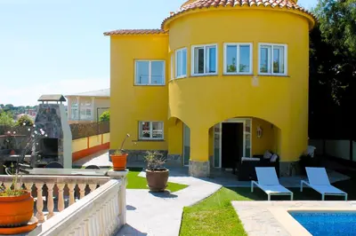a yellow house with a pool in front of it at House with Pool and Sea Views in Alella