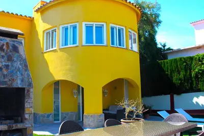 a yellow house with a table in front of it at House with Pool and Sea Views in Alella