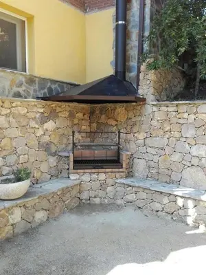 a stone wall with a stove in a house at Casa Xixella a 15 min de Sitges in Olivella