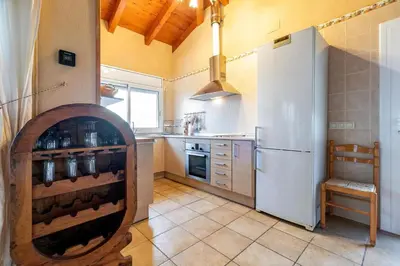 a kitchen with a large white refrigerator and a counter at Casa Xixella a 15 min de Sitges in Olivella