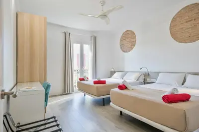 a bedroom with two beds and a chair at Stay Together Barcelona Apartments in Barcelona