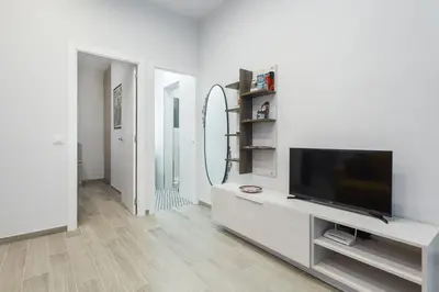 a living room with a tv and a mirror at Beautiful Apartment 20 minutes from city center in Hospitalet de Llobregat