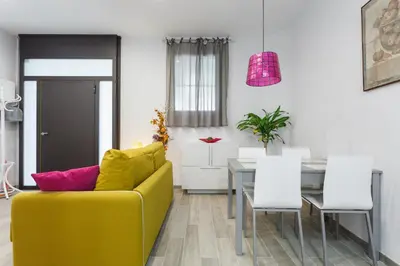 a living room with a yellow couch and a table at Beautiful Apartment 20 minutes from city center in Hospitalet de Llobregat
