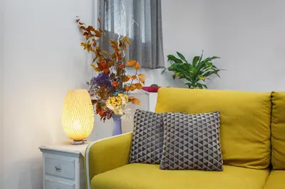 a yellow couch with a lamp on a side table at Beautiful Apartment 20 minutes from city center in Hospitalet de Llobregat