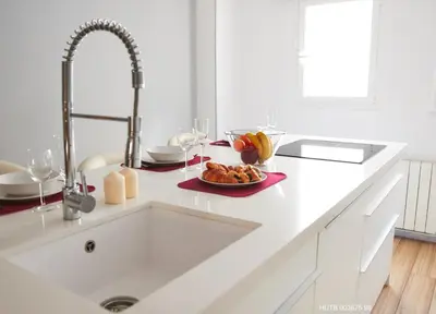 a white kitchen with a sink and a plate of food at Alcam Alio Cine in Barcelona