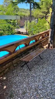 a wooden bench sitting next to a swimming pool at Loft Vacarisses Torreblanca Estación, Piscina Privada in Vacarisas