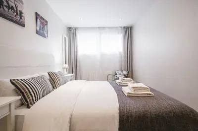 a white bedroom with a bed with towels on it at Tendency Apartments Forum 2 in Barcelona