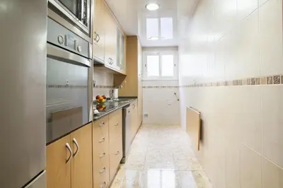 a kitchen with wooden cabinets and stainless steel appliances at Tendency Apartments Forum 2 in Barcelona