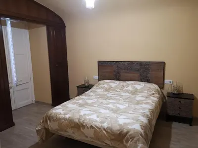 a bedroom with a large bed and two night stands at Cal Duran in Esparreguera