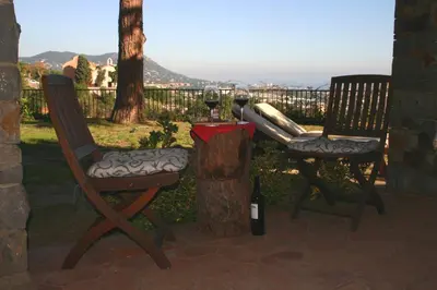 two chairs and a table with a glass of wine at B&B Premium in Premia de Dalt