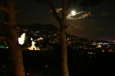 a full moon over a city at night at B&B Premium in Premia de Dalt