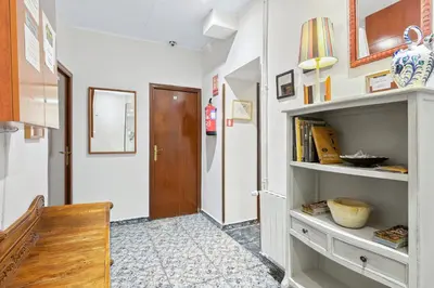 a hallway with a door and a shelf with books at Hostal Santa Ana in Barcelona